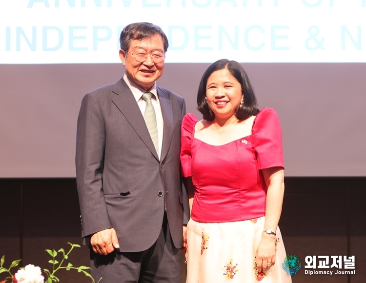 &nbsp;Ambassador Theresa Dizon De Vega of the Philippines clad in red upper-wear and pink skirts (right) poses with one of the Korean guests on the stage of the Regency Ballroom of the Grand Hyatt Seoul in celebration of the 125th anniversary of Independence of the Philippines from Spain.