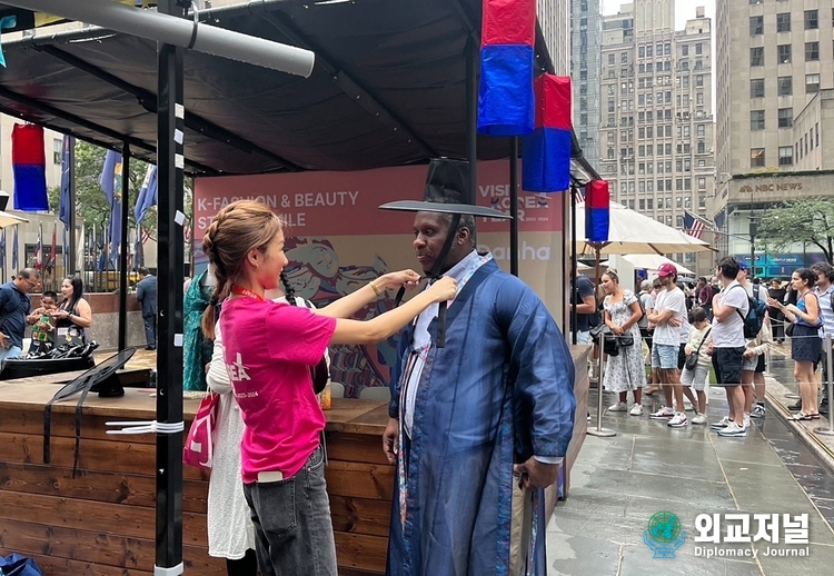 &nbsp; Visitors at the event try on Hanbok (traditional Korean clothes) at a promotional booth in NY's Rockefeller Center.