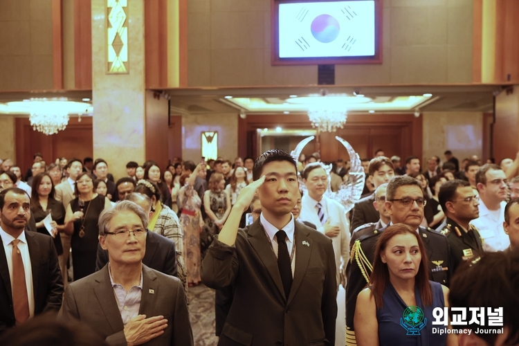 Participants in the Uzbek event salute the national flags of Uzbekistan and Korea.