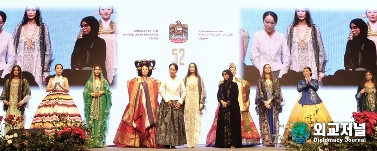 Models from the UAE and South Korea in traditional clothing walk the catwalk.